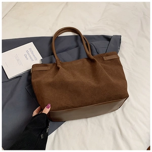 Détail du grand sac cabas montrant le contraste du daim brun et du cuir lisse