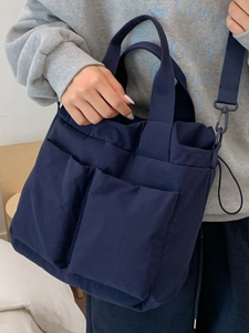 Minimalist navy blue multi-pocket crossbody bag for students shown in a lifestyle scene