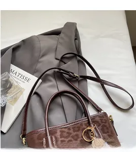 Detail showing leopard print fur texture and adjustable brown leather shoulder strap