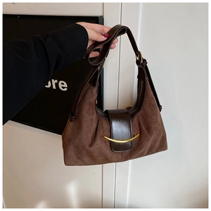 Détail du sac demi-lune en daim marron avec garniture en cuir foncé et boucle dorée