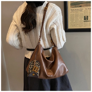 Brown leather Hobo tote bag featuring horse-shoe leopard charm and golden B-letter charm