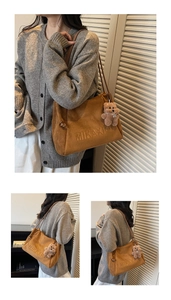 Details der braunen Vintage-Tasche mit Buchstabenprägung und Plüschbär-Anhänger
