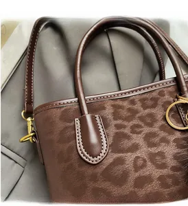 Detailed macro view of the soft leopard print texture and durable brown leather handles