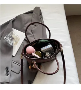 Detail showing high-capacity interior of a dark brown leather tote bag with daily essentials
