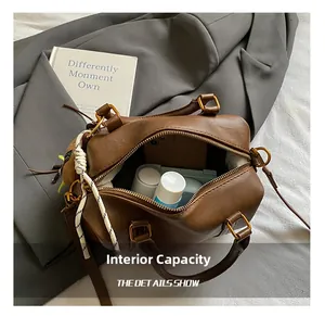 Detail view of brown Boston bag interior with capacity for phone and cosmetics