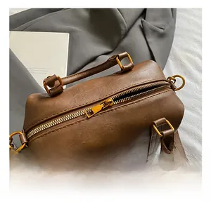 Detail of high-quality golden metal zipper and brown leather texture on Boston bag