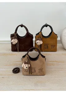 Détail de sacs en daim en marron, jaune et beige avec des motifs de gâteaux mignons
