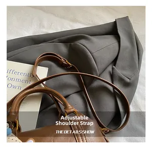 Detail view of a brown leather handbag with an adjustable strap and decorative floral scarf