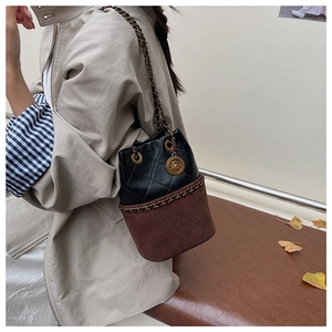 Detail of leopard print bucket bag featuring diamond quilting and gold floral pendant
