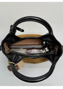 Vue intérieure du sac à main en daim marron montrant sa grande capacité de rangement
