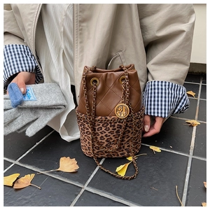 Detail of leopard print bucket bag with diamond lattice pattern and gold COCO pendant