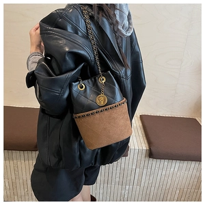 Detail of leopard bucket bag with gold chain strap and drawstring closure on model