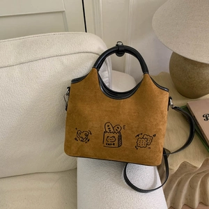 Vue détaillée du sac à bandoulière en daim caramel avec des illustrations de gâteaux mignons