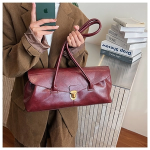 Detail of burgundy vintage square bag with glossy texture and golden metal clasp