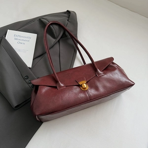 Detail shot of vintage burgundy square bag with metallic buckle and leather texture