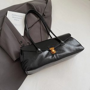 Detail of vintage black square shoulder bag featuring gold buckle and wrinkled leather texture