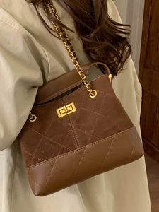 Deep brown bucket bag with quilted suede, chain strap, and gold-tone turn-lock clasp