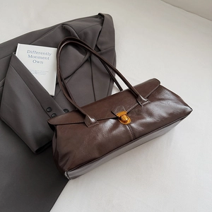 Detail view of dark brown faux leather shoulder bag with gold hardware and smooth finish