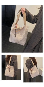 Dettaglio della borsa tote trapuntata beige con motivi a rombi e ciondolo con animaletto