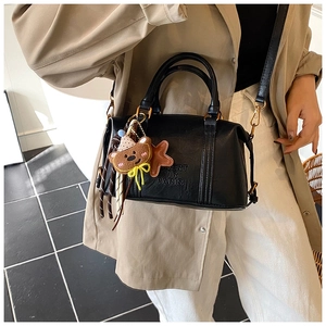Detail of black matte leather bag with BERT AIR PARIS embossing and bear charm