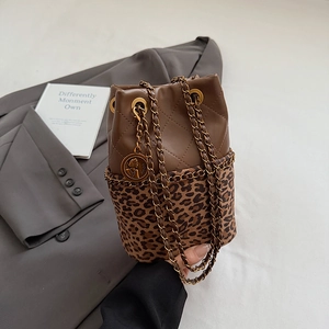 Detail view of leopard print bucket bag with quilted brown leather and gold chain