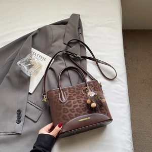 Brown leopard print PU leather handbag with plush charm and adjustable shoulder strap