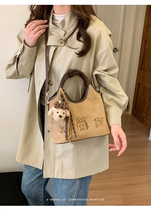 Détail du sac cabas rétro en similicuir avec illustration de pain et breloque chien