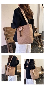 Dettaglio della borsa tote trapuntata marrone chiaro con texture imbottita e ciondolo