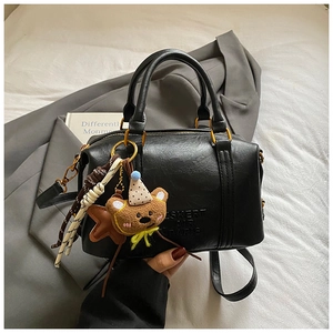 Detail of black Boston bag with embossed SKERT AIR PARIS lettering and bear charm