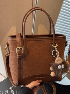 Brown leopard print suede handbag with adjustable strap and plush monster pendant