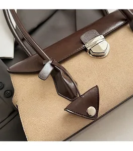 Detail of vintage suede Boston bag with silver twist-lock and contrast stitching