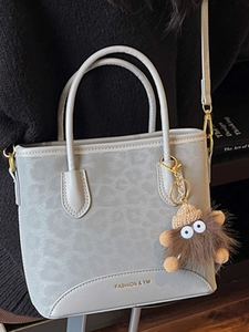 Retro grey leopard print shoulder bag with plush charm and stylish gold logo detail