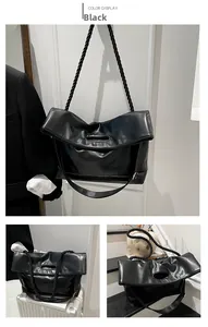Detail view of black tote bag with unique woven rope shoulder strap and oval handle