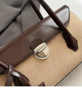 Close-up of vintage Boston bag featuring a silver metal clasp and two-tone leather texture