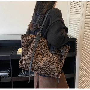 Sac fourre-tout tendance à motif léopard avec bandoulières en cuir noir porté par un mannequin