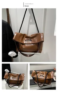Detail view of brown PU leather tote with fold-over design and black rope handle