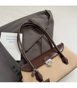 Close-up of contrast leather Boston bag featuring suede texture and silver metal lock