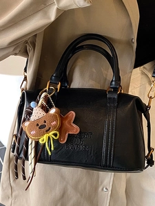 Elegant black Boston handbag with BERT AIR PARIS embossing and cute bear charm accessories