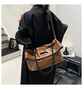 Brown soft leather bag with hollow handle and woven rope detail shown on a model