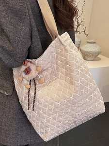 Elegante borsa tote trapuntata beige con trama a rombi e ciondolo a forma di pecora