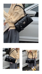Close-up of black retro leather shoulder bag with metallic silver twist lock closure