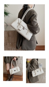 Detailed close-up showing the silver heart-shaped rotating metal lock on off-white bag