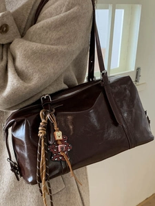 Minimalist vintage dark brown shoulder bag with a shiny oil wax leather finish and bear charm