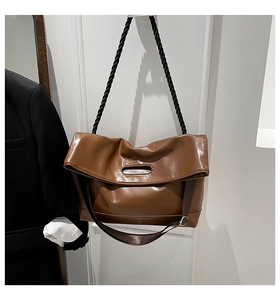 Close-up of brown PU leather tote with black braided rope and nylon double straps