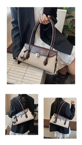 Detail view of retro color-block Boston bag with silver metal swivel lock and strap
