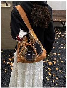 Detail of retro plaid tote bag with brown suede strap and cute white rabbit charm