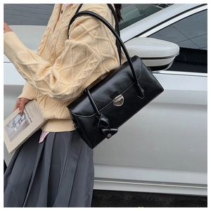 Detail of vintage black leather Boston bag with iconic silver metal turn-lock closure