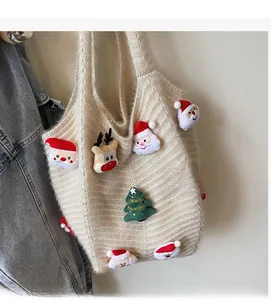 Detail of crochet tote bag with plush Christmas Santa, reindeer and tree decorations