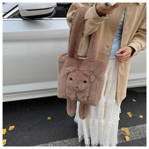 Detailansicht der braunen Plüschtasche mit Teddybär-Design getragen von Model