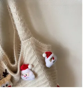 Detail of light beige knitted bag with 3D plush Santa Claus and reindeer decorations